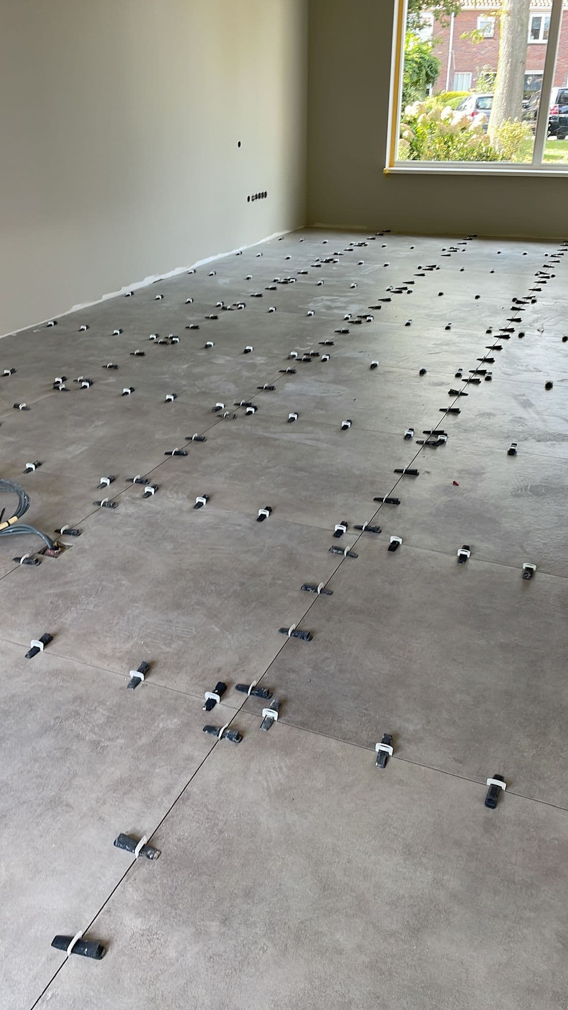 Grootformaat vloertegels worden op maat gelegd met levellers, Kemp Tegelwerk Haarlem