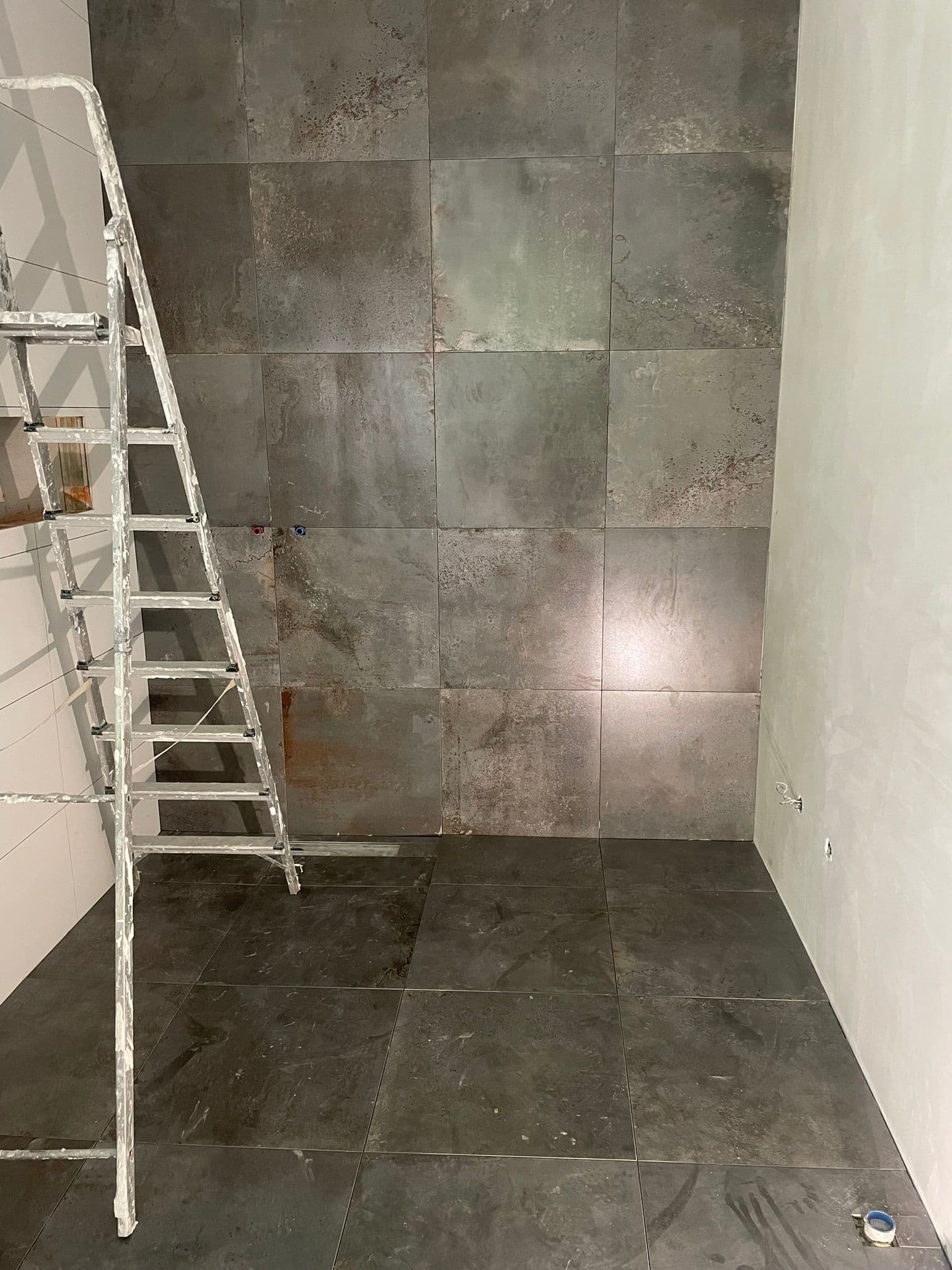 Badkamer met metallic roestlook wandtegels en donkere grijze vloer, Kemp Tegelwerk Zandvoort